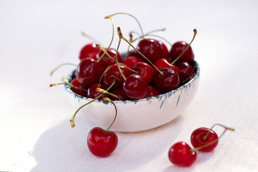 Sweet cherries, in and in front of a bowl