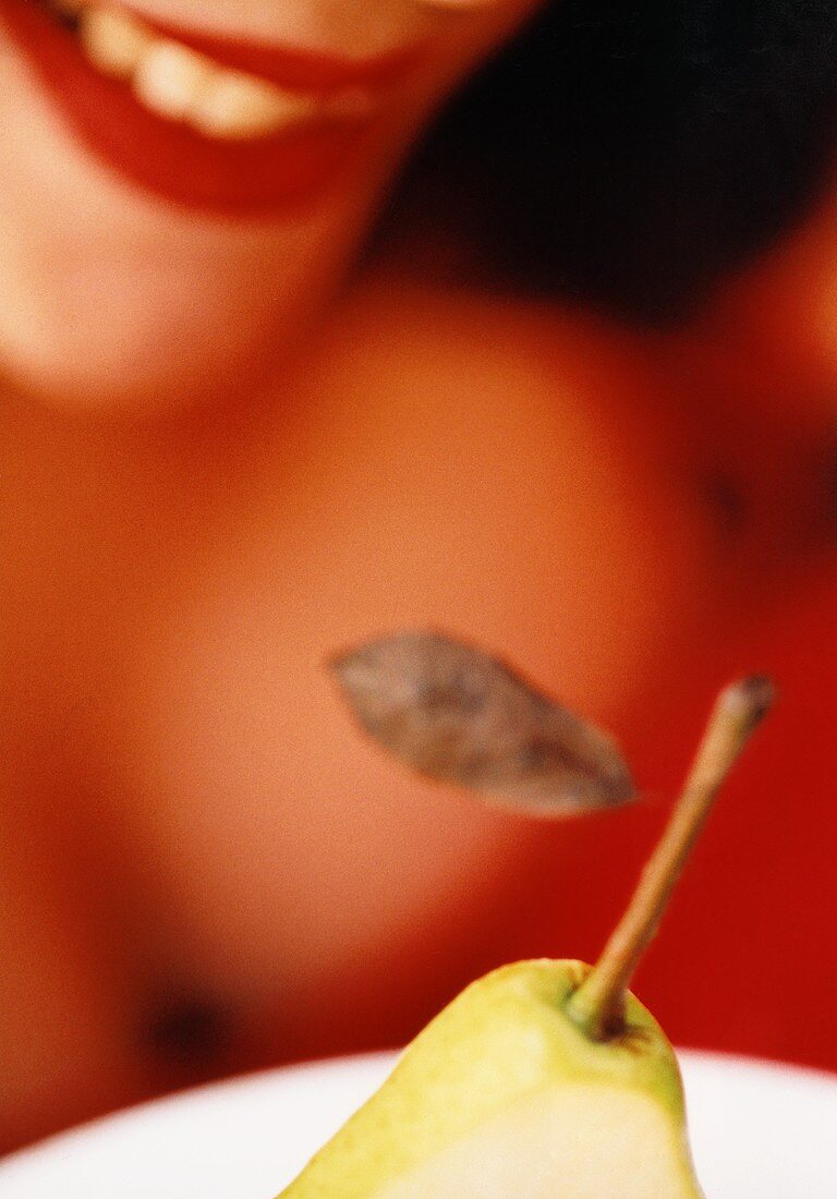 Pear in front of woman with red lips (close-up)