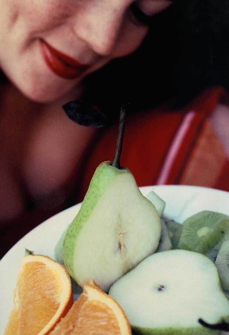 Woman looking at plate of fruit