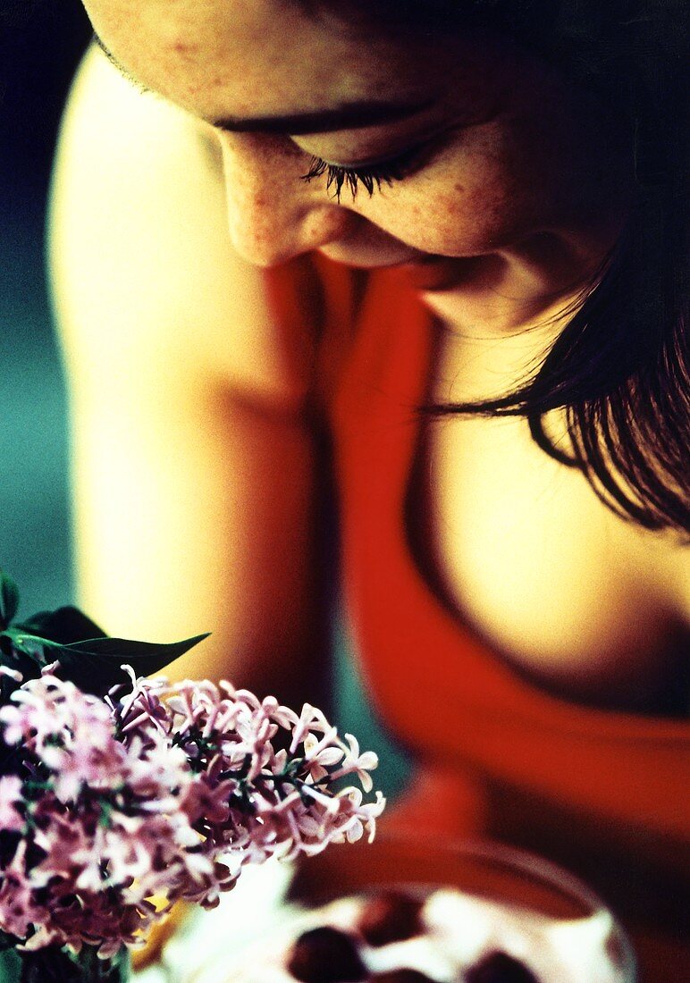 Woman in red dress bending over a dessert; lilac