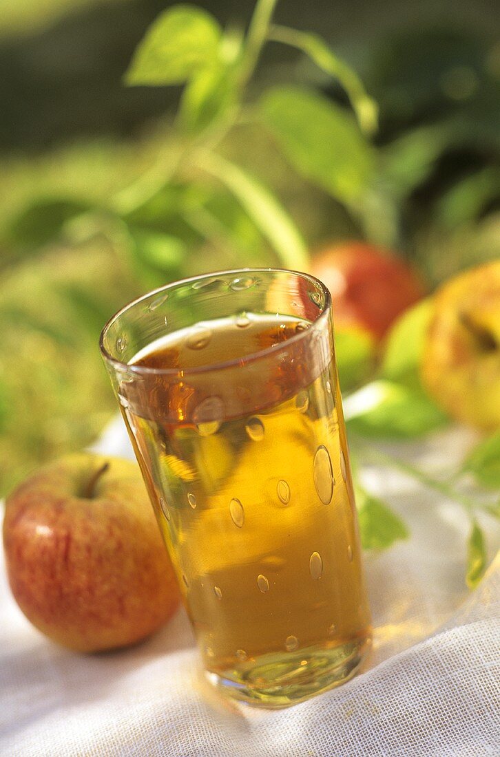 Ein Glas Apfelsaft und frische Äpfel (Sorte Gala Royal)