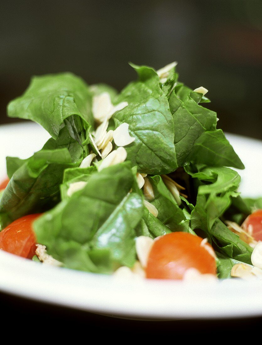 Spinach salad with tomatoes and flaked almonds