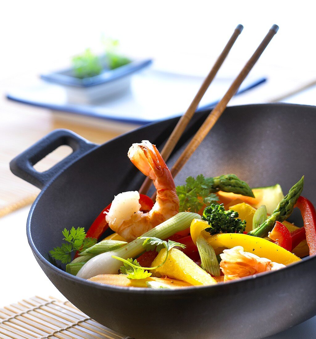 Wok with vegetables and shrimps, chopsticks