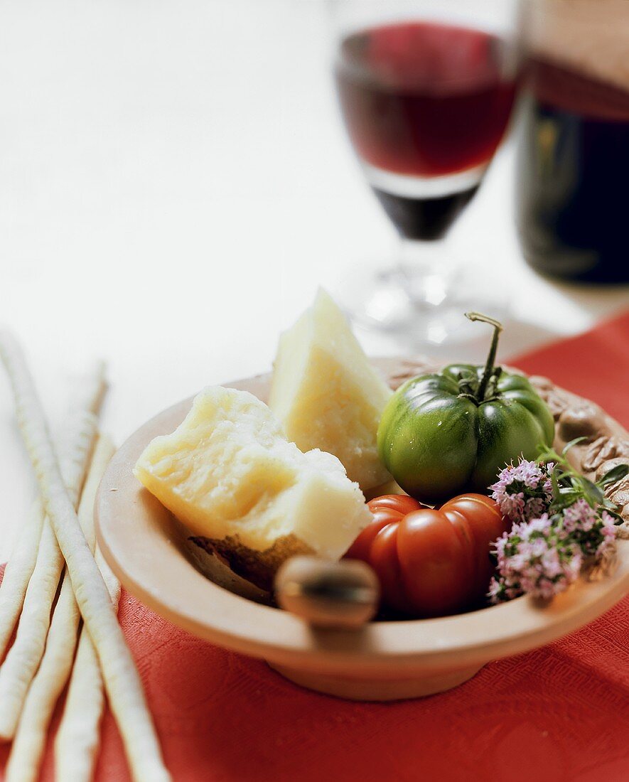 Italienisches Stillleben mit Parmesan, Tomaten, Grissini, Wein