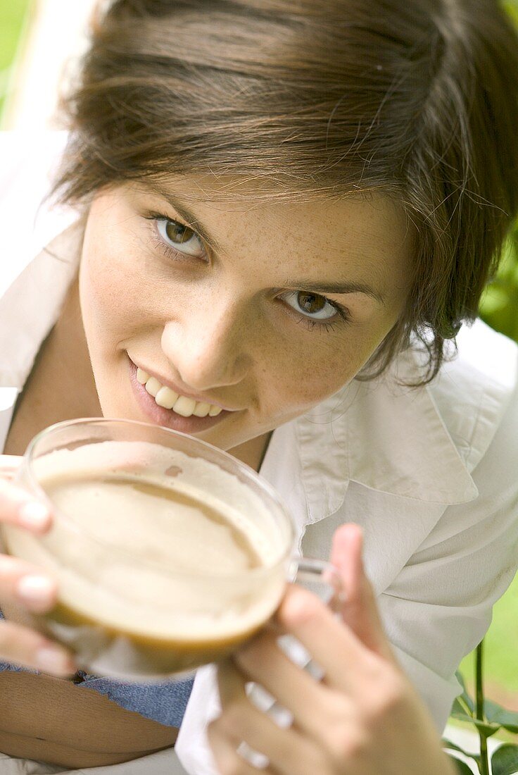Woman with white coffee in a glass cup