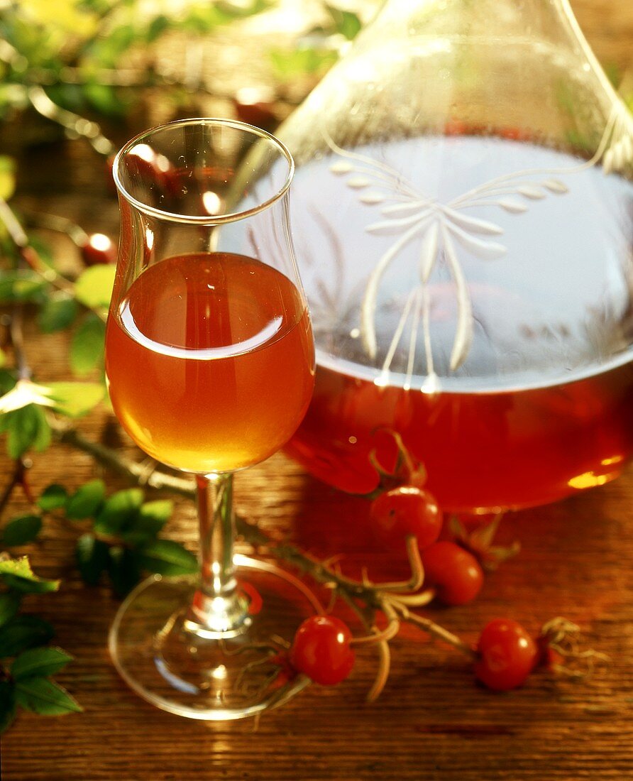 Hagebuttenlikör in Glas und Flasche