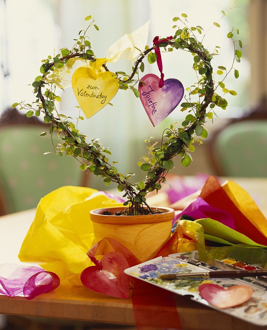 Flowerpot with heart-shaped plant and paper hearts