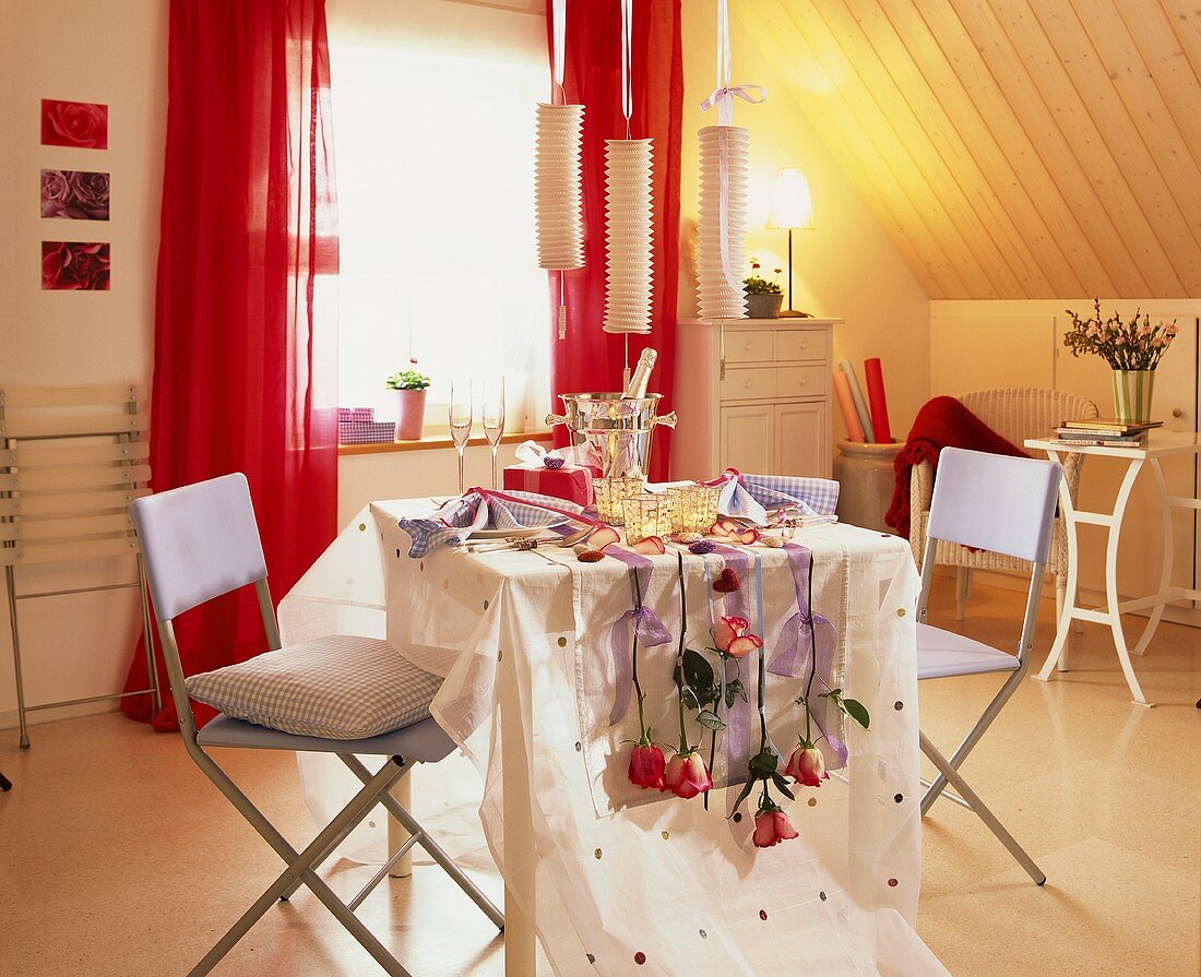 Romatisch gedeckter Tisch für Zwei mit Sekt und Rosendeko