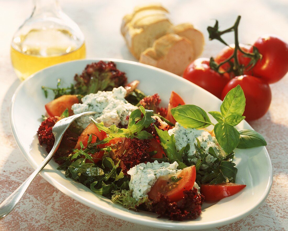 Mixed salad leaves with tomatoes & soft cheese with herbs