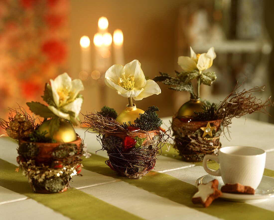 Drei weihnachtlich dekorierte Tontöpfchen als Tischdeko