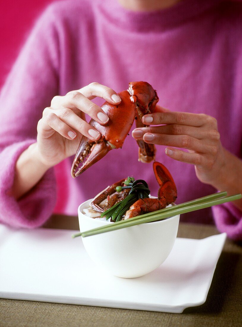Woman eating crab dish (red-clawed crab)