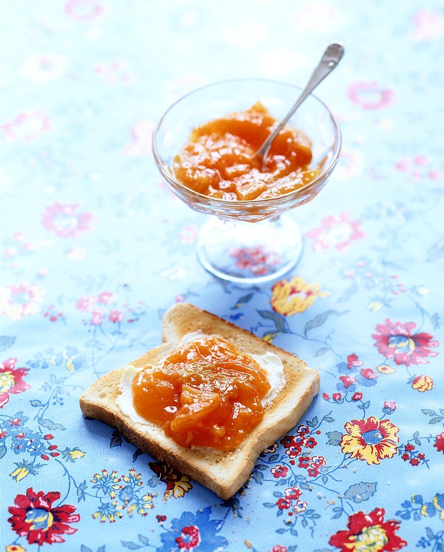 Apricot jam on toast and in glass bowl