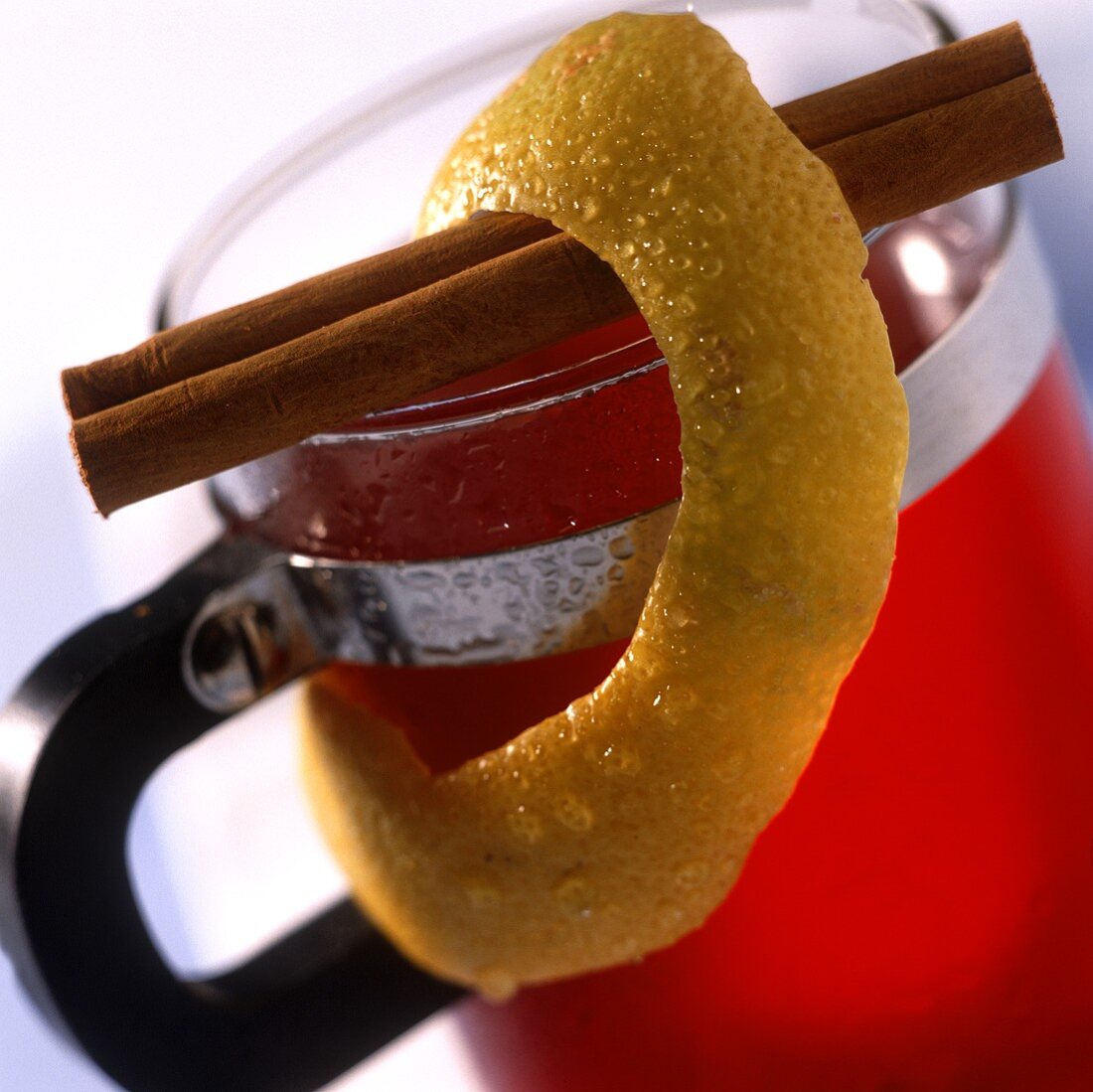 Mulled wine in glass, lemon rind and cinnamon stick