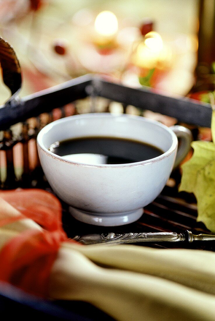 Tasse schwarzer Kaffee auf Tablett mit Herbstdeko