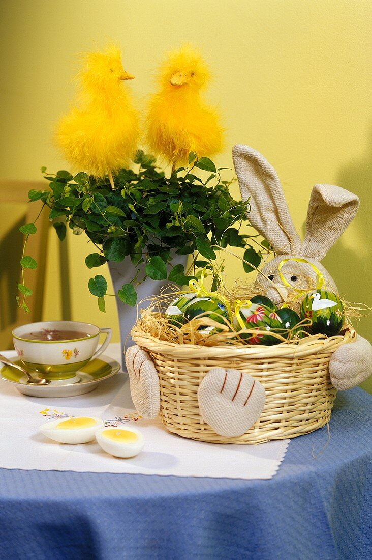 Osterkörbchen mit bunten Eiern als Tischdekoration