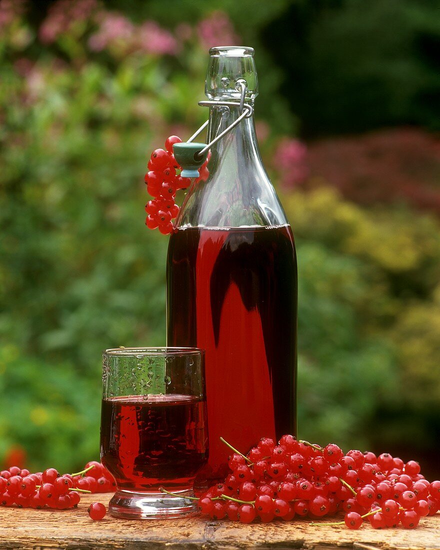 Roter Johannisbeersaft in Flasche und Glas