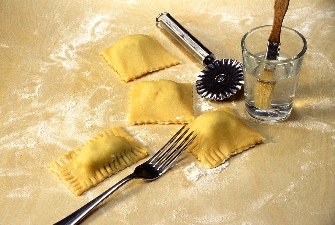 Sealing the edges of ravioli with the prongs of a fork