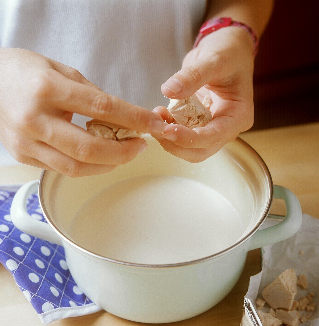 Crumbling yeast into lukewarm milk