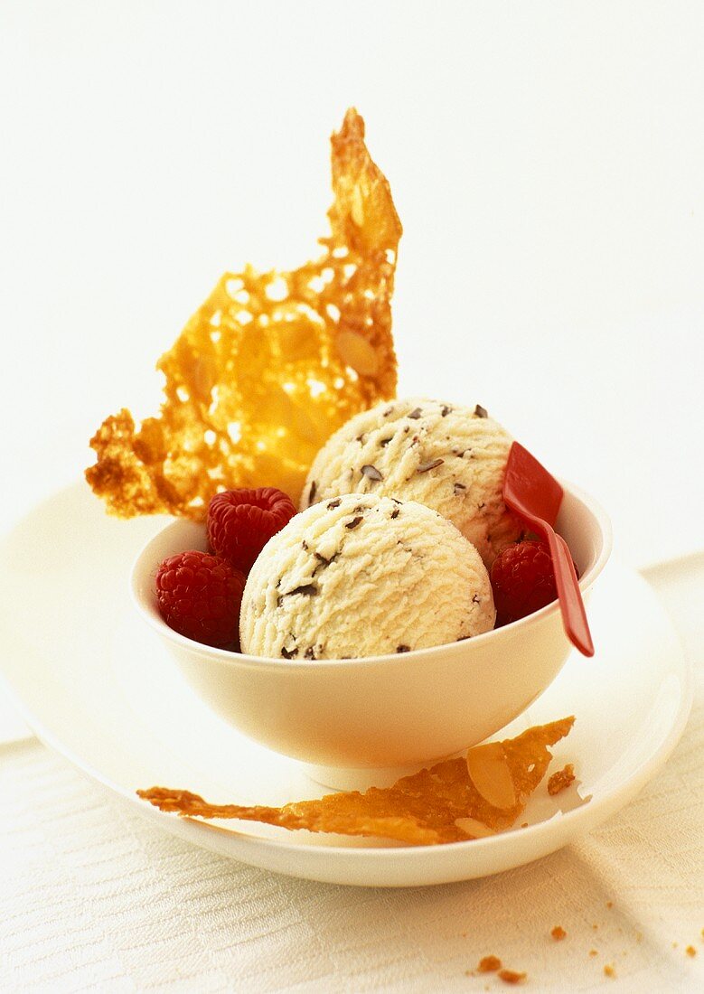 Stracciatella ice cream with almond wafers and raspberries