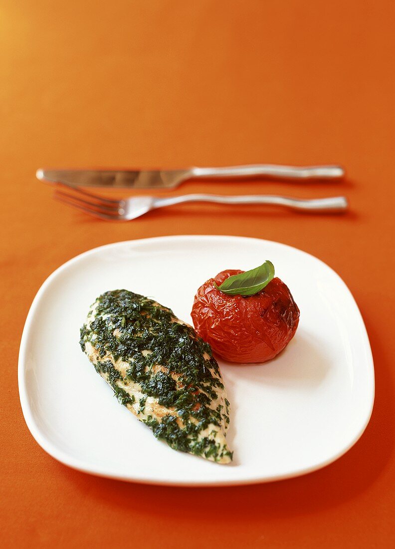 Chicken breast with herb sauce and baked tomato