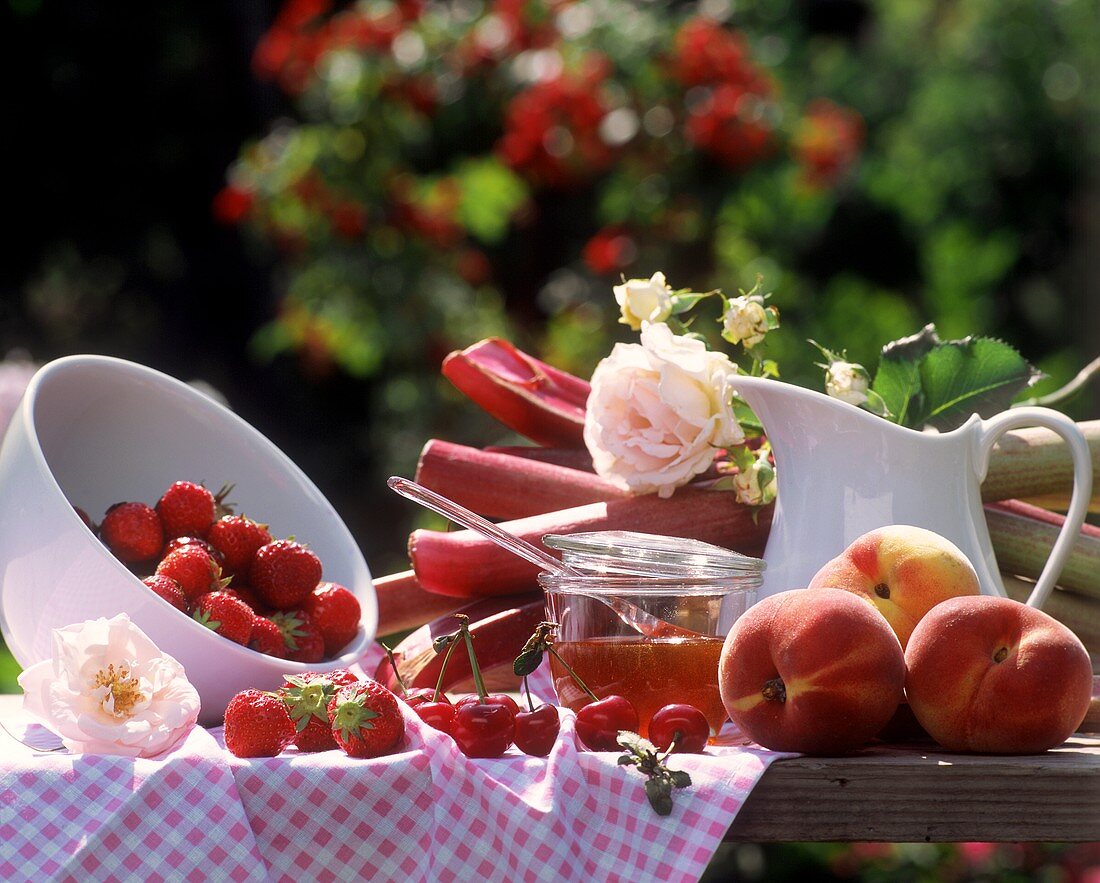 Pfirsiche, Erdbeeren und Rhabarber auf einem Gartentisch
