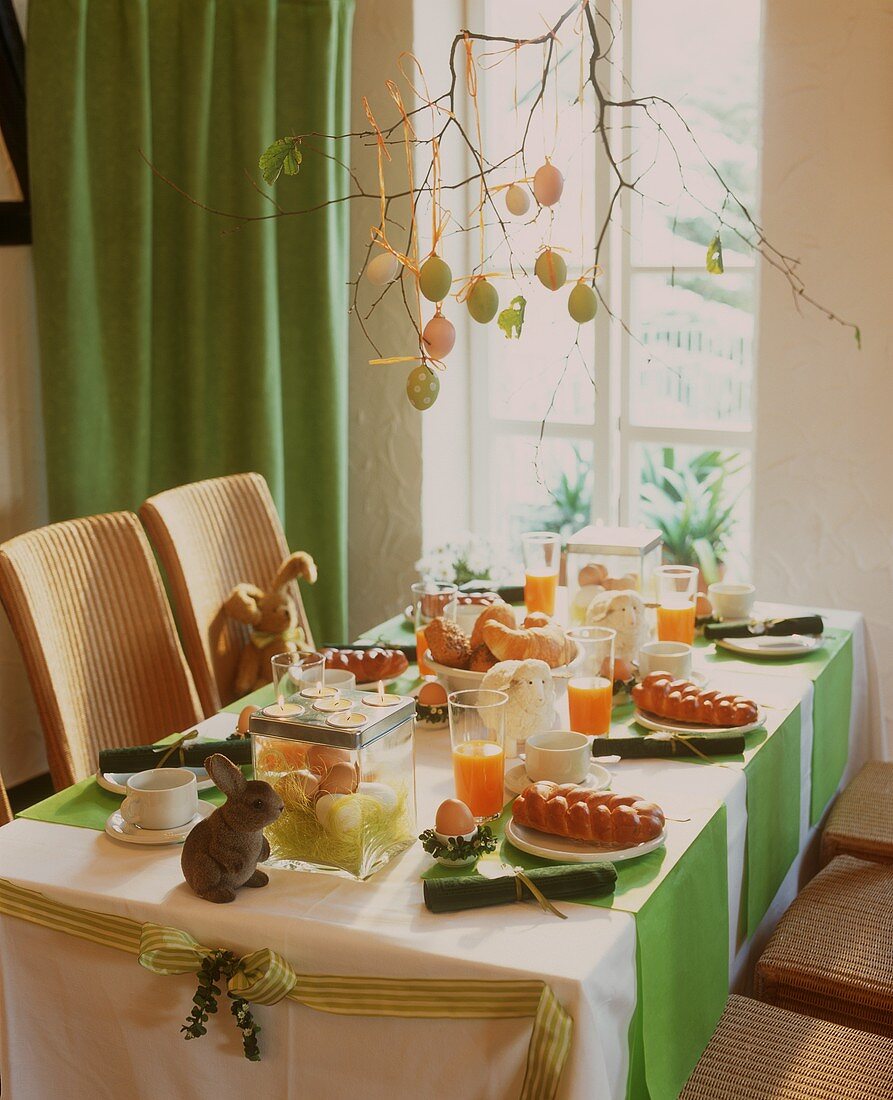 Laid breakfast table with bread plait for Easter