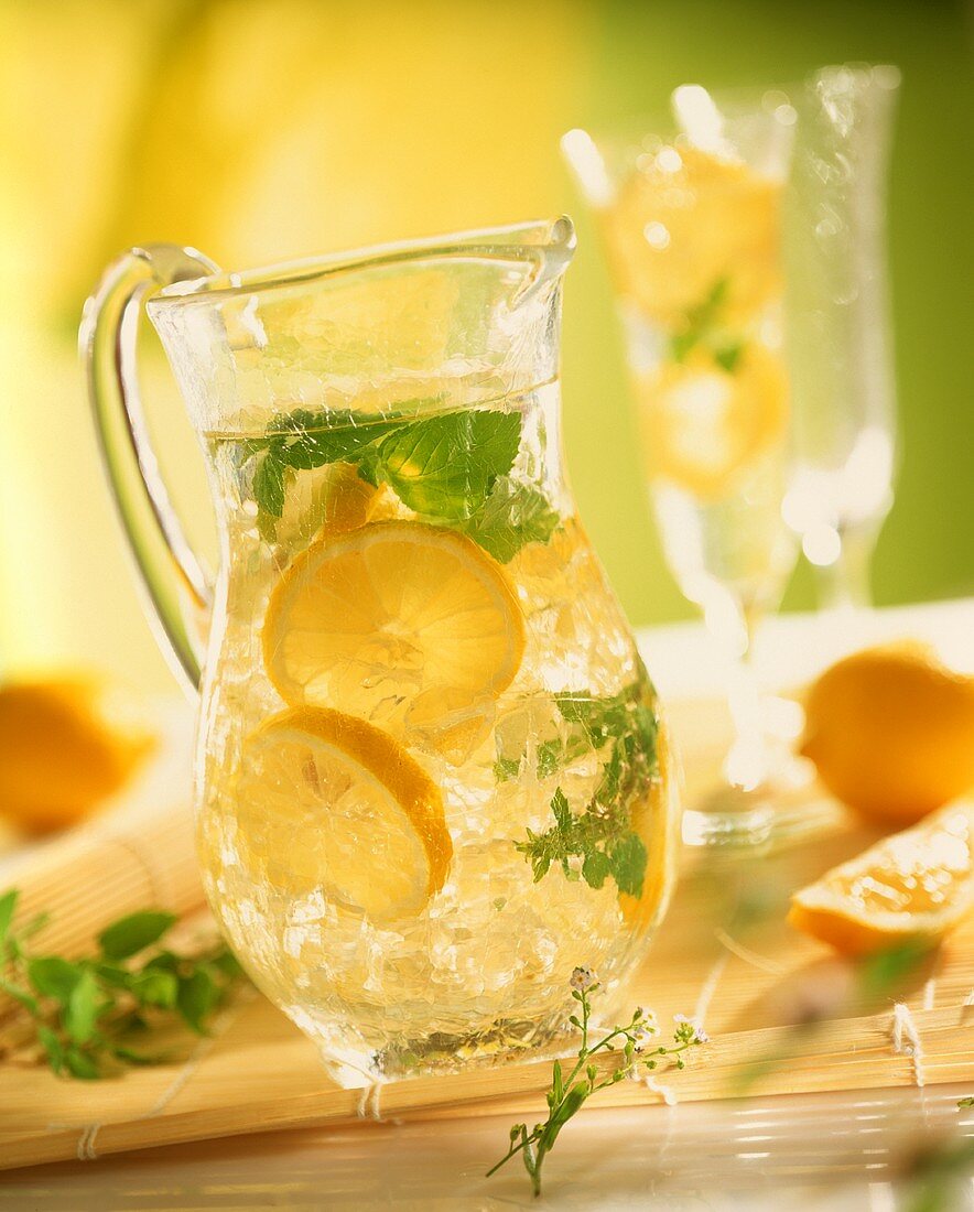 Lemonade with ice cubes and mint leaves in jug