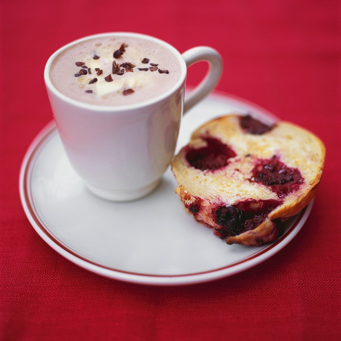 A cup of chocolate and a piece of blackberry muffin