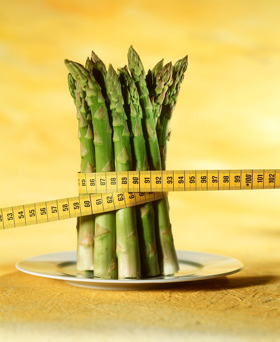 Green asparagus spears with tape measure