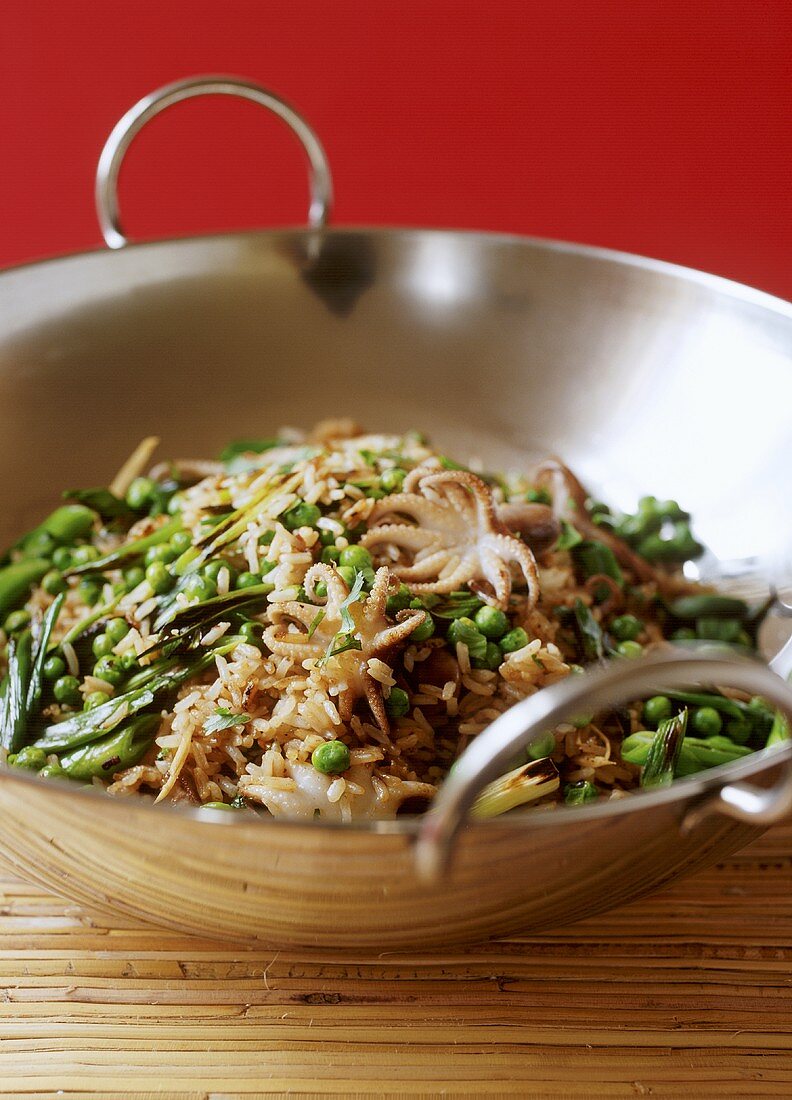 Fried rice with vegetables and squid in wok