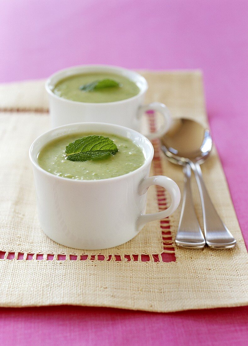 Erbsensuppe mit Minze in Tassen