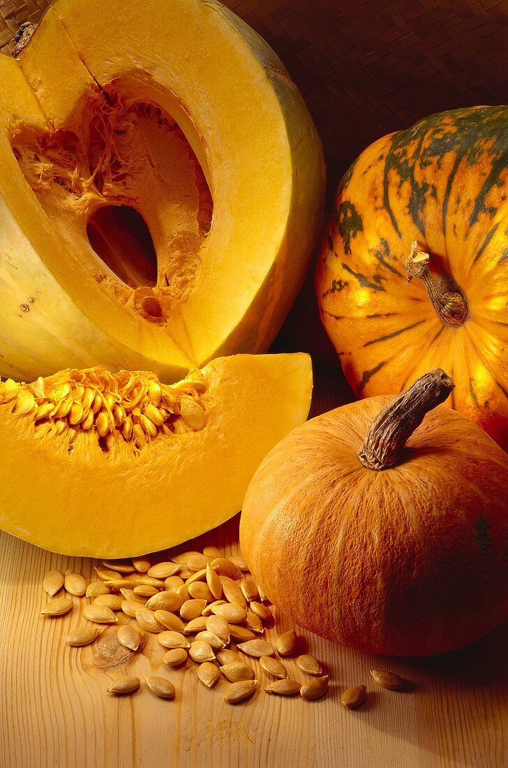 Whole pumpkins, pumpkin with piece cut and pumpkin seeds