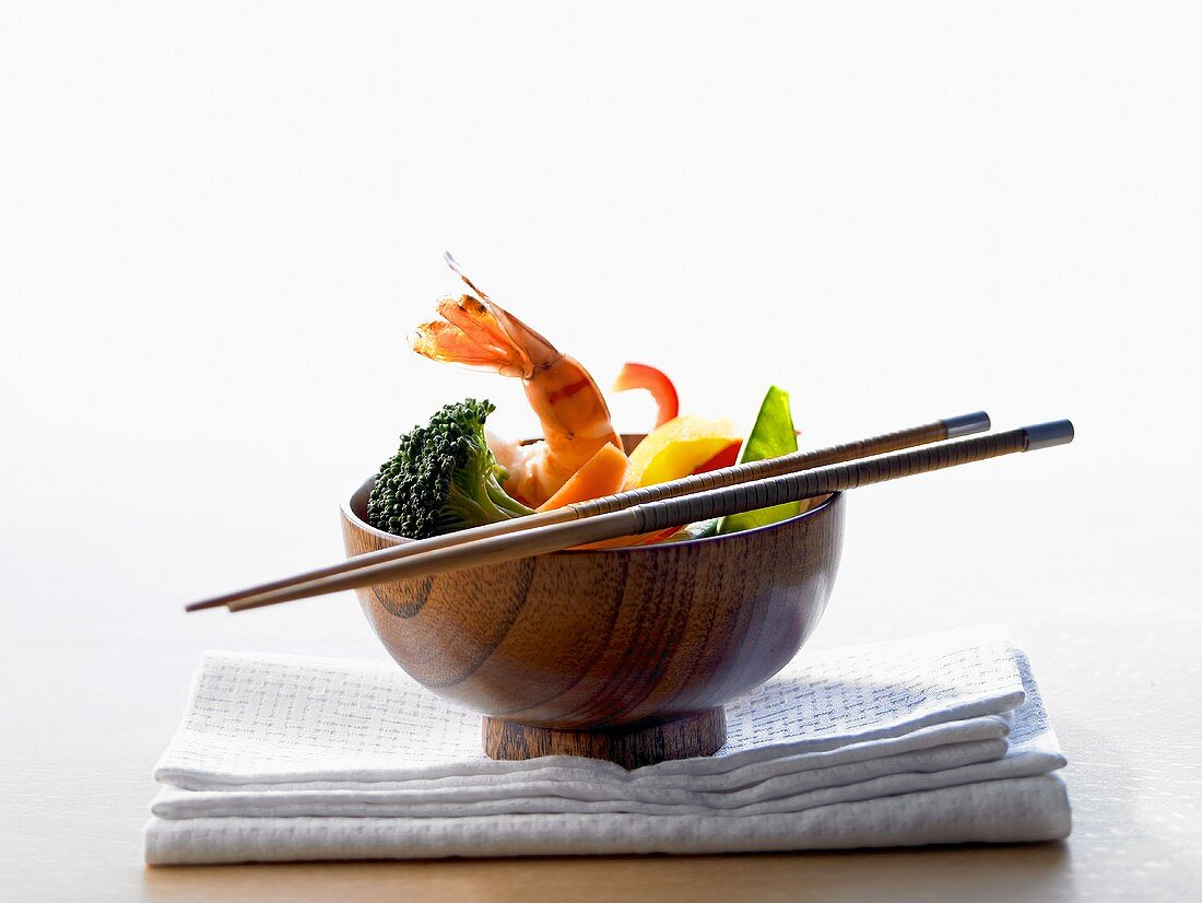 Bowl of vegetables and shrimps; chopsticks