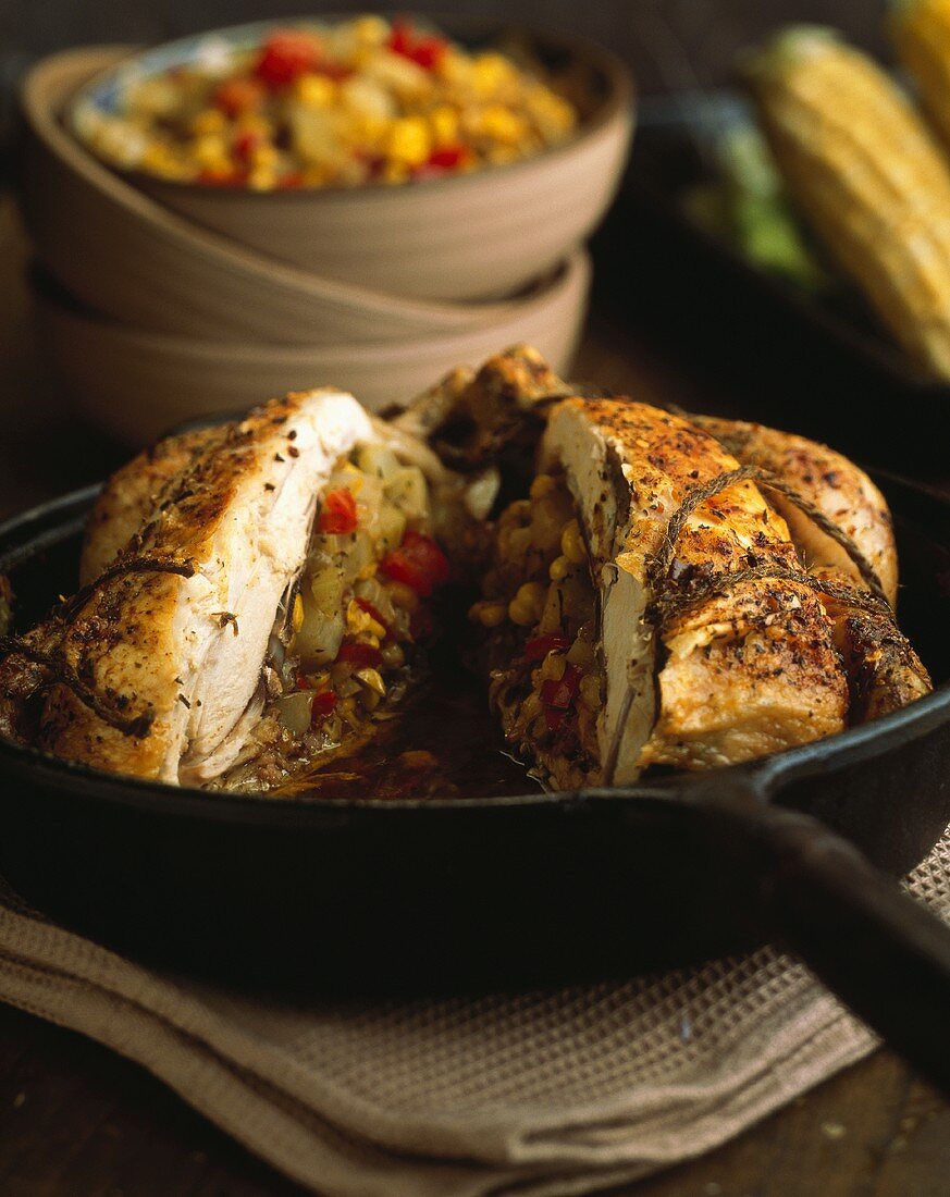 Halved stuffed chicken in an iron pan