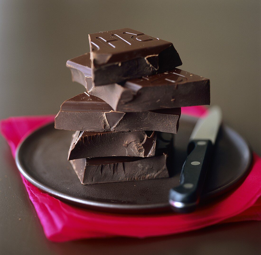 A pile of pieces of Valrhona chocolate on black plate