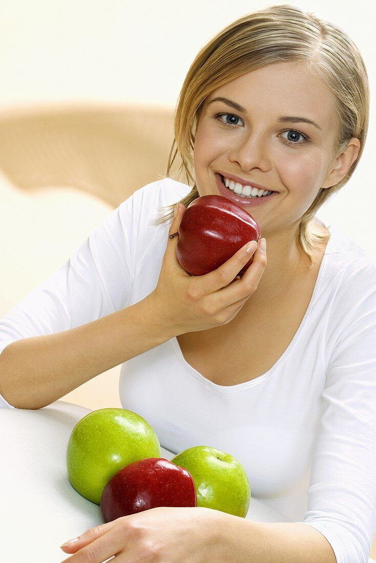 Young woman with four apples