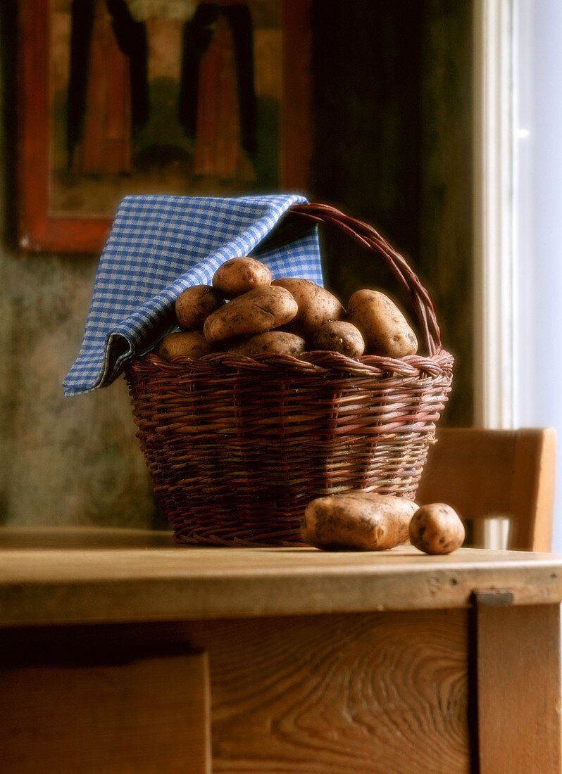 Frisch geerntete Kartoffeln in einem Korb auf Küchentisch