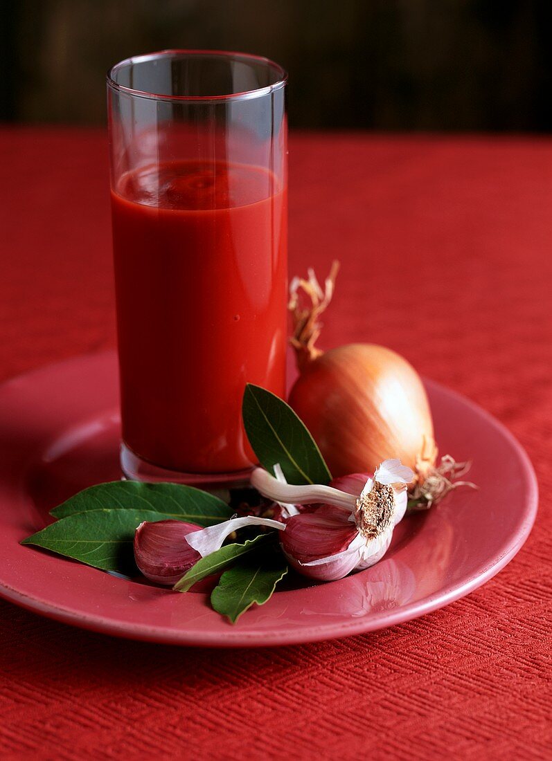 Tomato sauce in a glass on table with ingredients