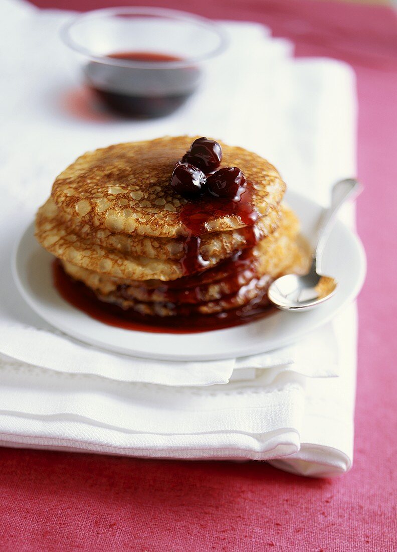 A pile of blinis with cherry compote