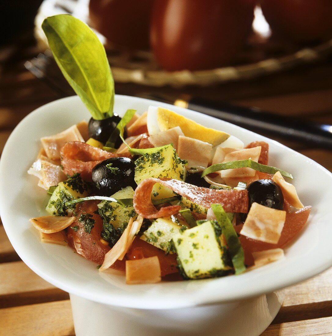 Schinkensalat mit Käse, Tomaten und schwarzen Oliven