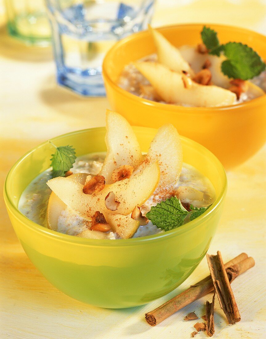 Zwei Schälchen Porridge (Haferbrei) mit Birnen & Haselnüssen