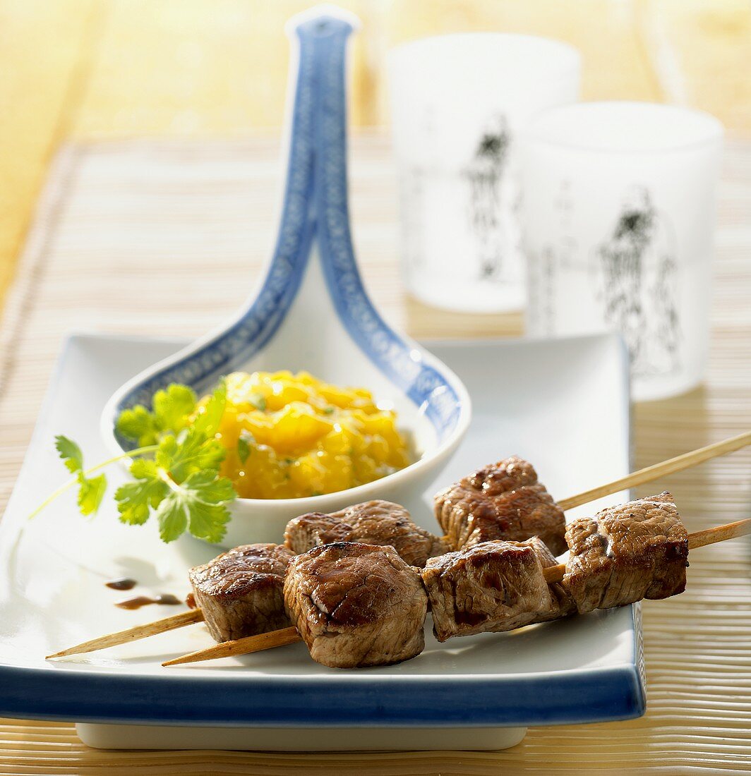 Two beef kebabs with mango chutney on a spoon
