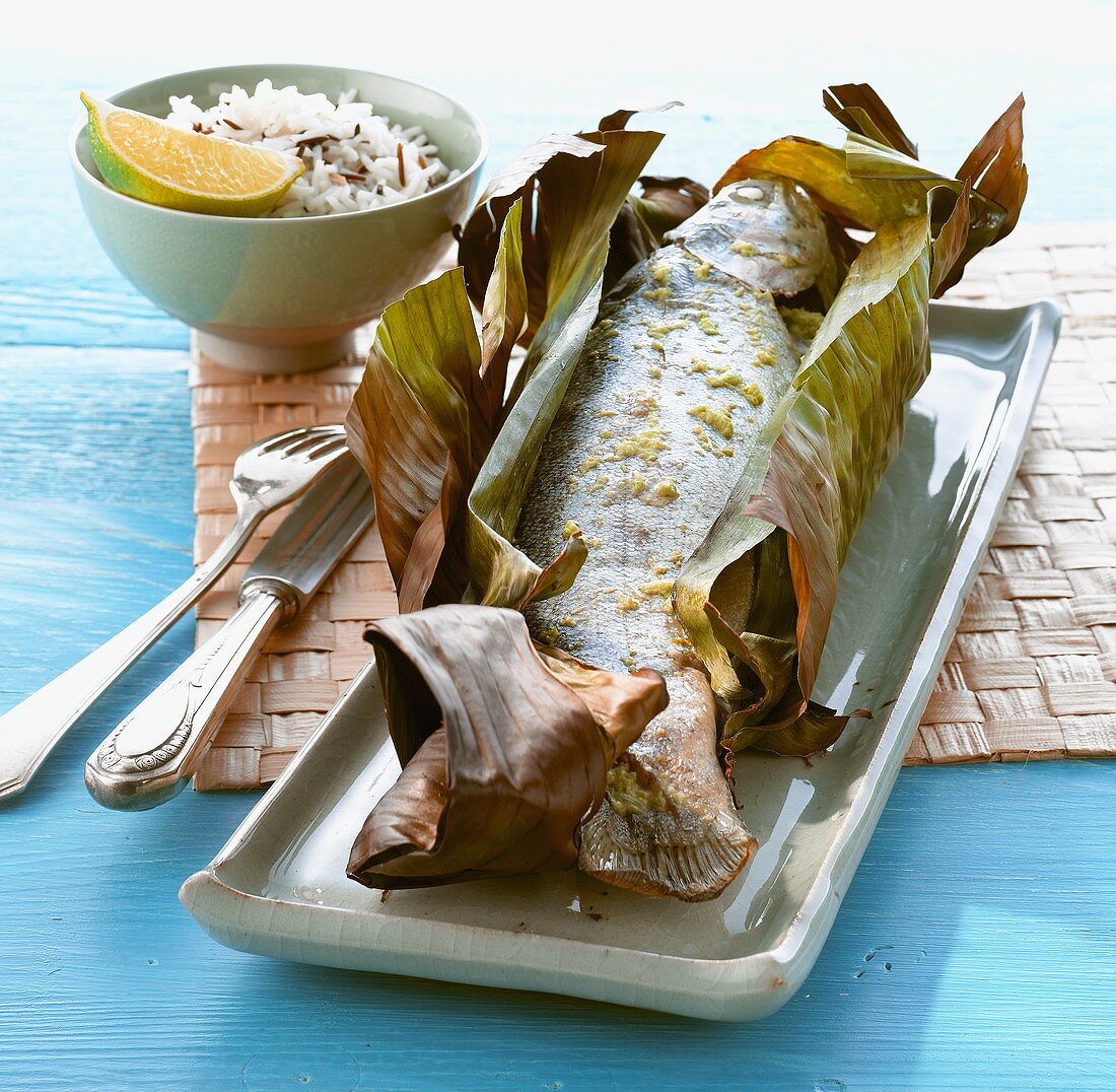 A trout in banana leaf with rice (Thailand)