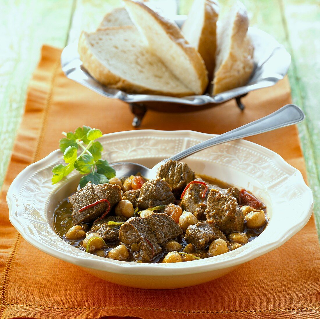 Lamb and chick-pea stew with a bread basket (India)