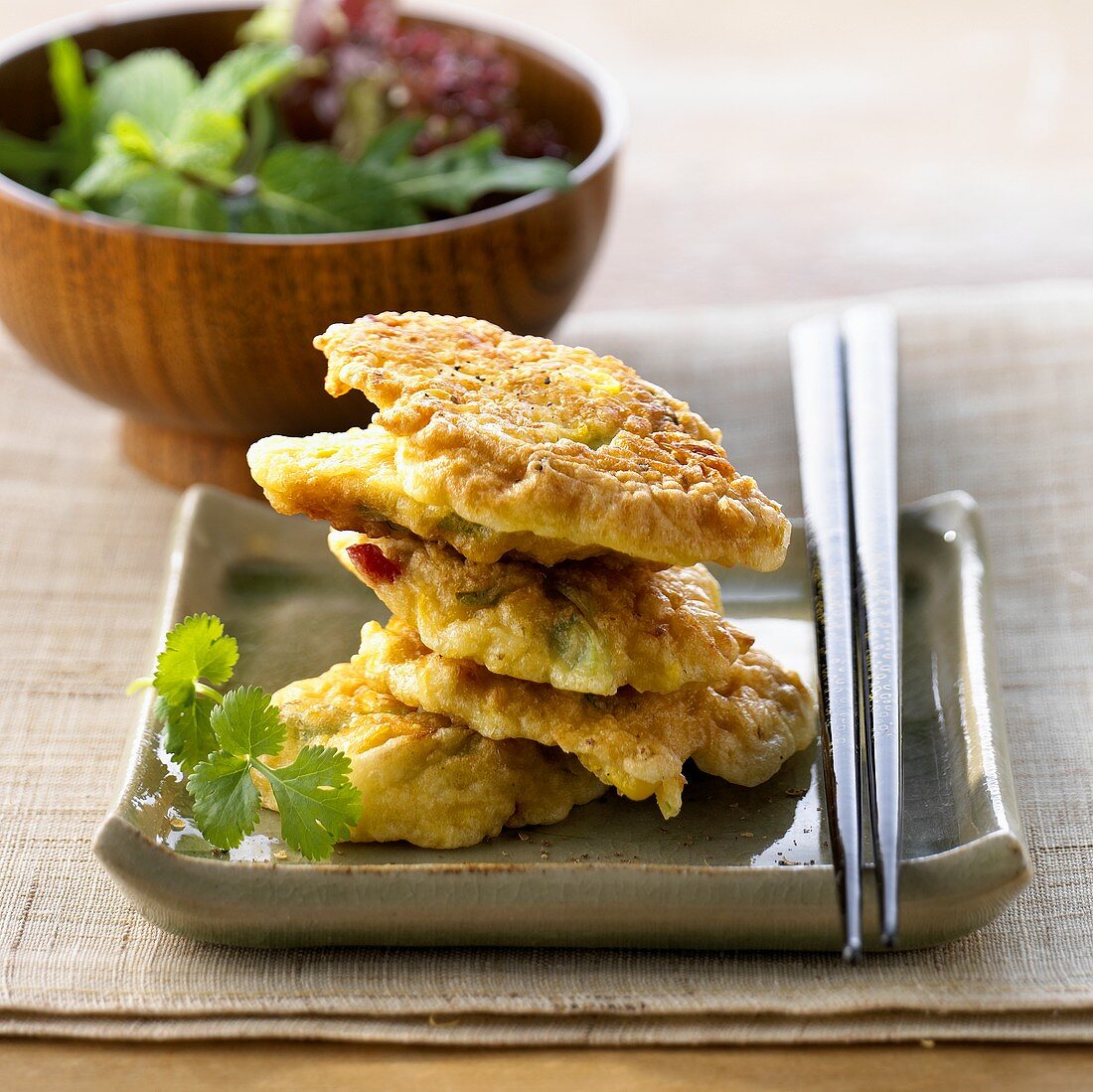 Sweetcorn cakes in a pile with salad accompaniment