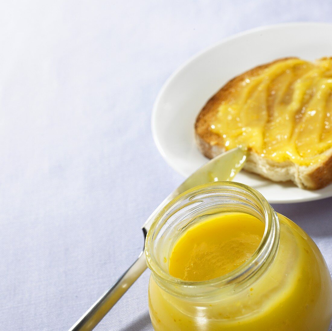 Lemon Curd (Zitronencreme) im Glas und auf Toast