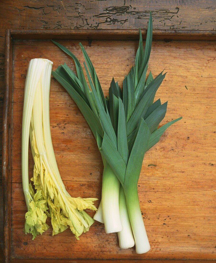 Celery and leeks on wooden background