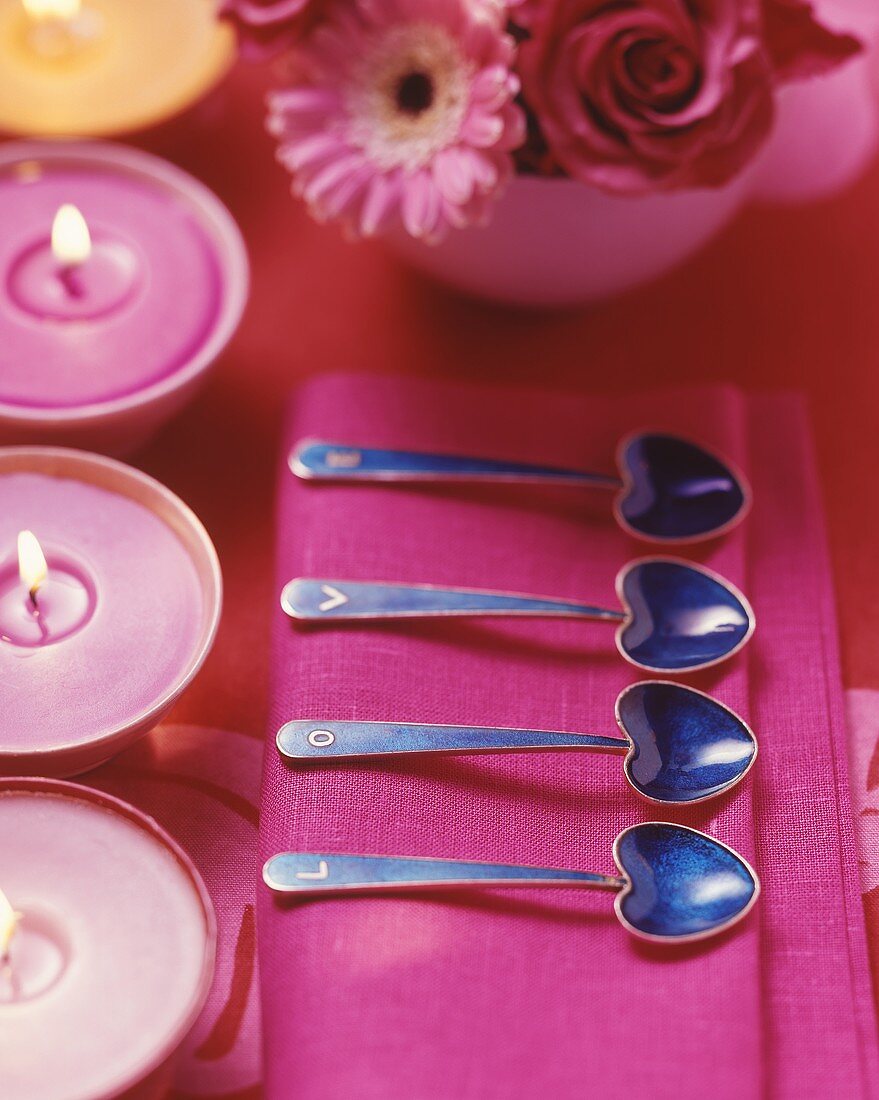 Place setting with heart-shaped spoons and candles