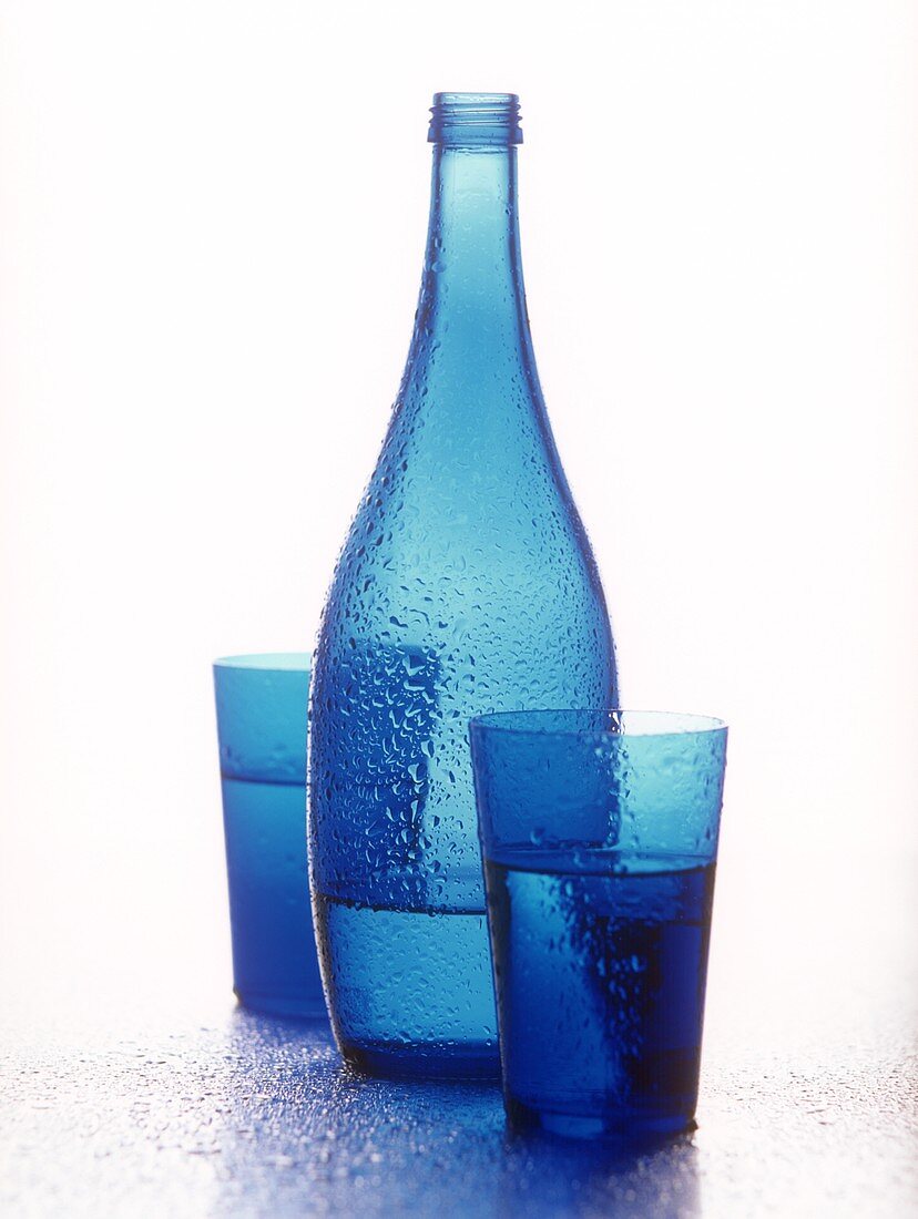 Blaue Flasche und zwei blaue Gläser mit Mineralwasser
