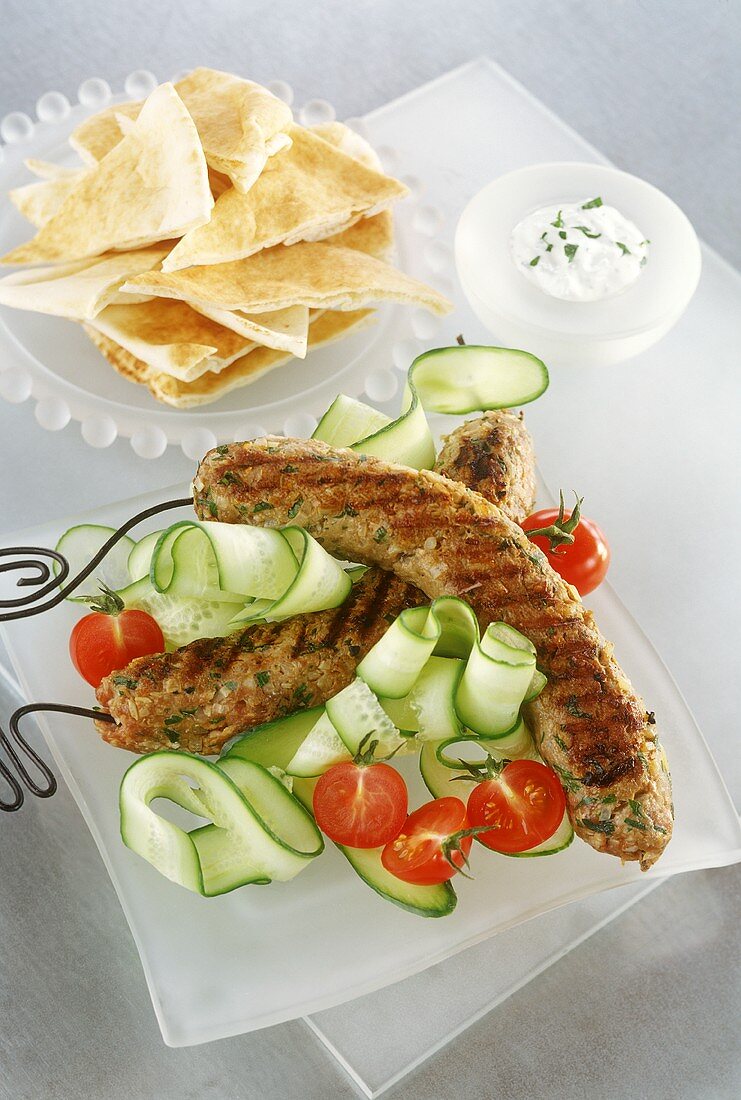 Skewered minced lamb rolls on cucumber slices